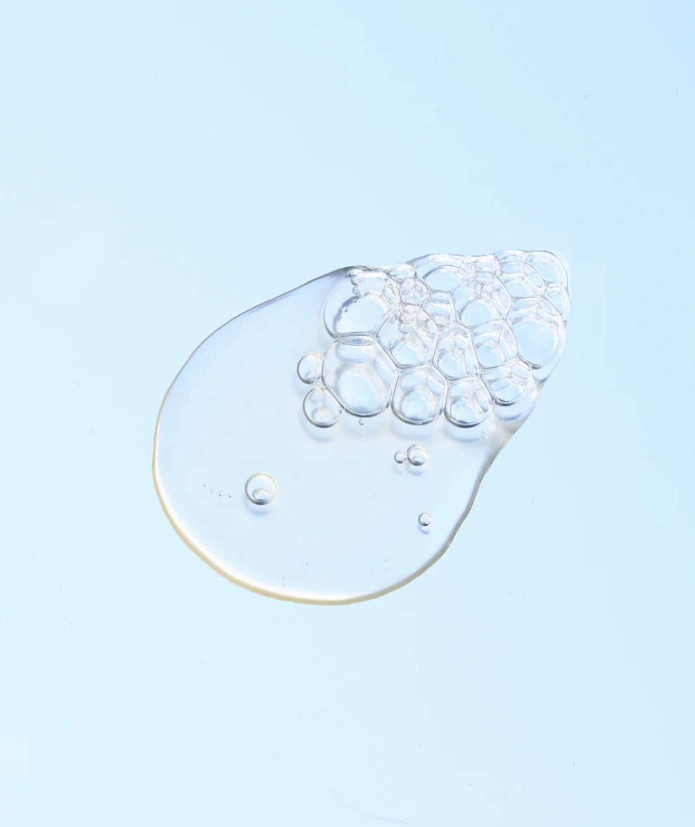 A clear gel with bubbles against a blue background, Tranexamic Acid.