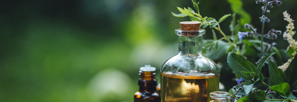 Glass bottle with Avarelle Multi-Dart Patch and cork surrounded by greenery, suggesting natural wellness or herbal essence.