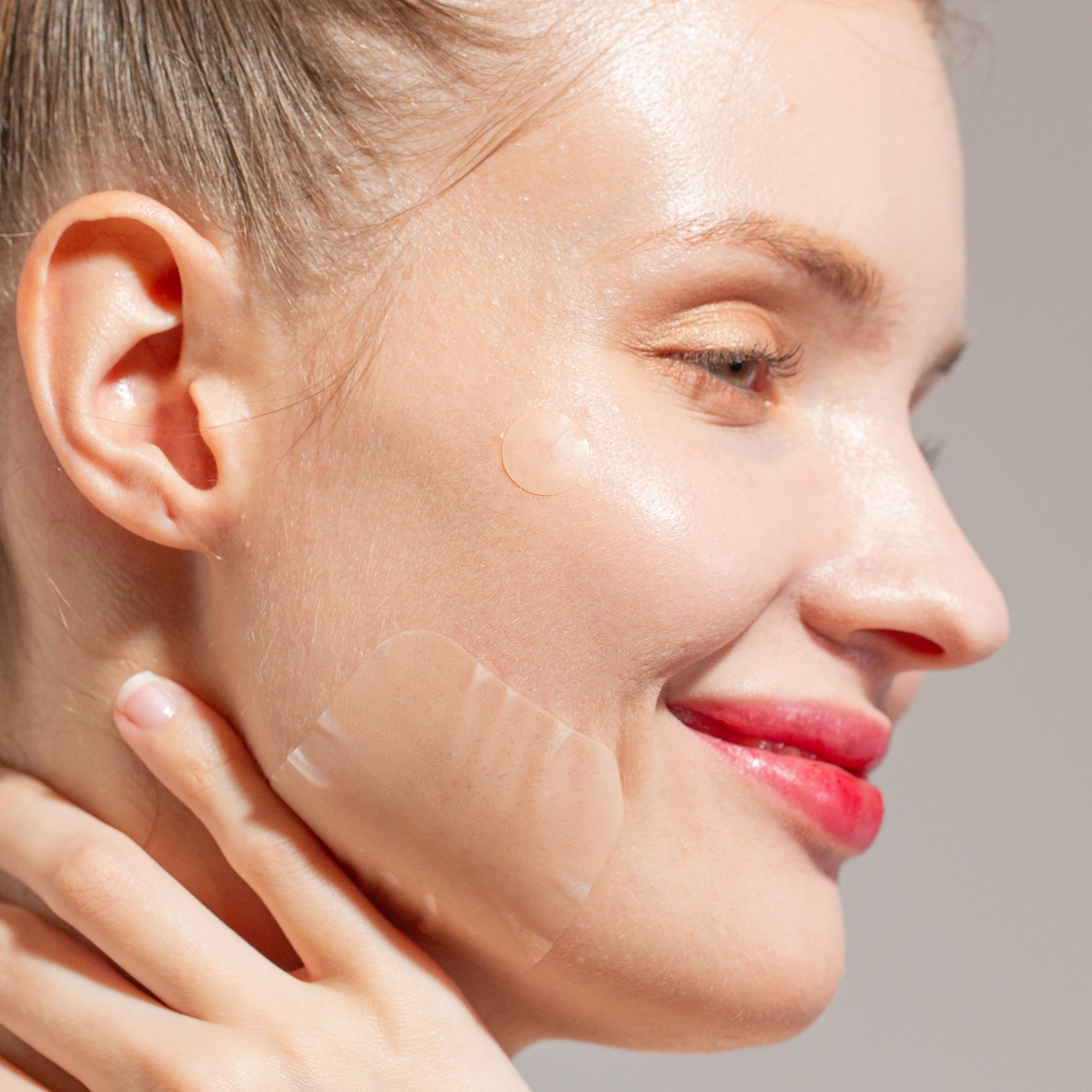 Woman with an Avarelle ZITOUT Variety Traveler's Pack 40CT hydrocolloid patch on her face smiling.