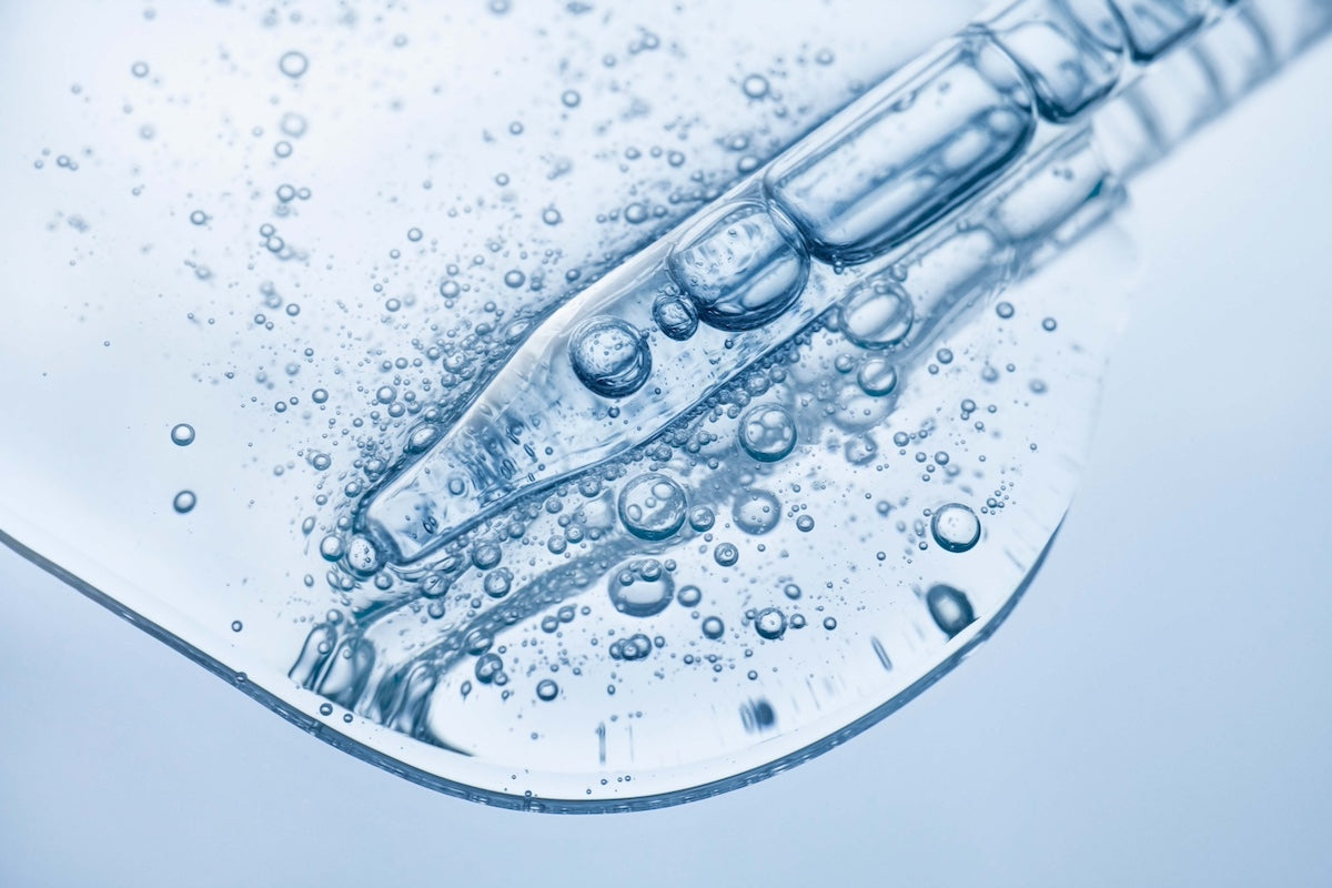 Pipette dispensing Niacinamide into a petri dish with bubbles forming.